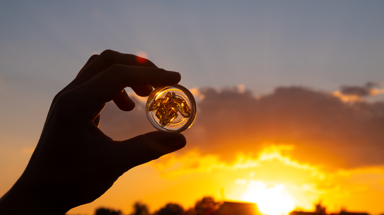 cannabis wax extract in container on sunset background, marijuana dab smoking mood