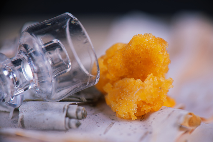 Marijuana extraction concentrate aka wax crumble on wood background how to smoke badder
